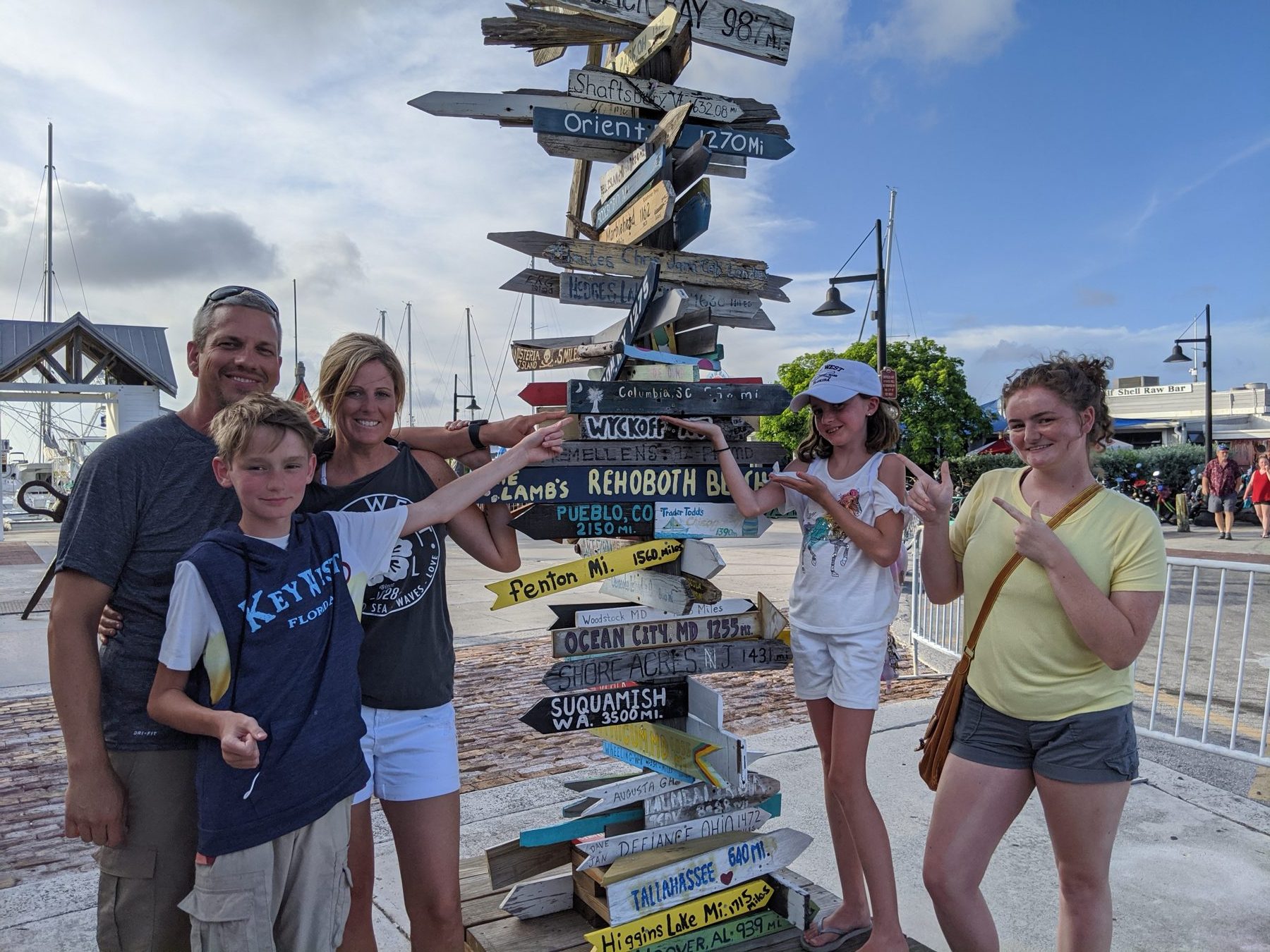 The Shannon family beside a signpost covered in destination arrows.